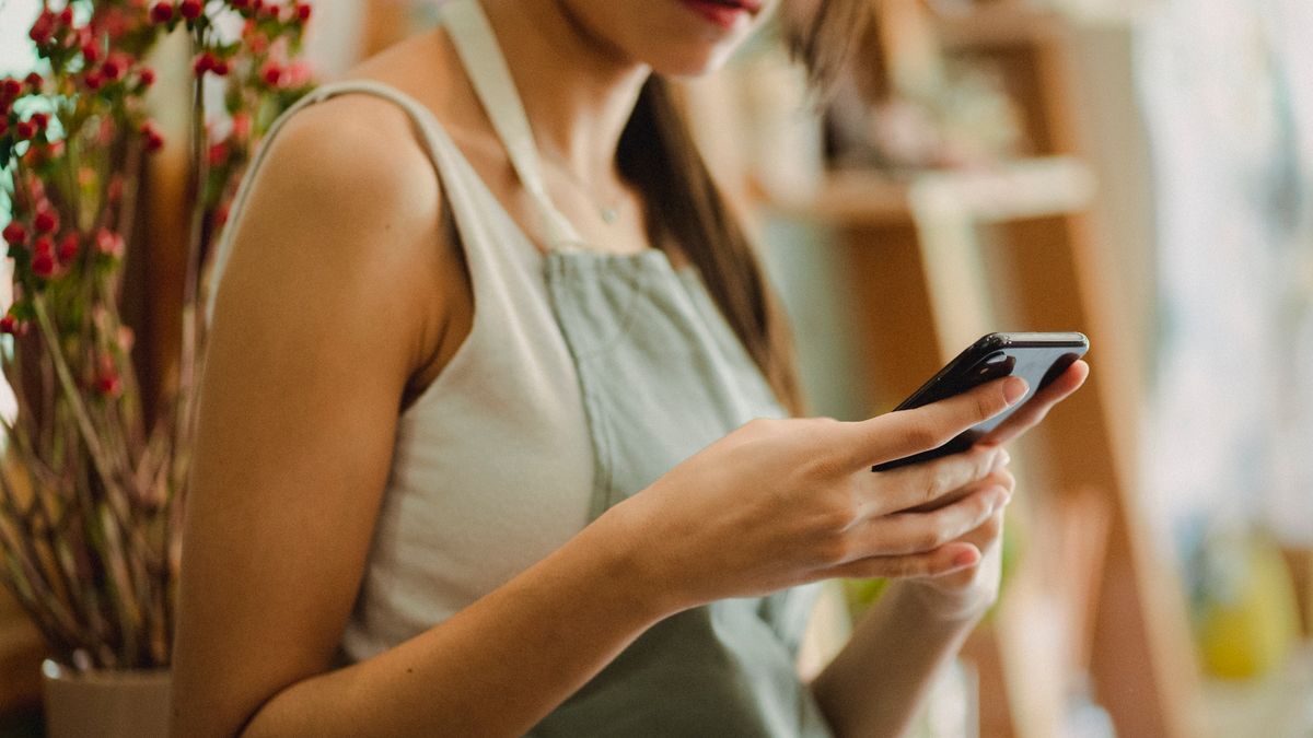 Una commerciante che scrive un messaggio dal telefono